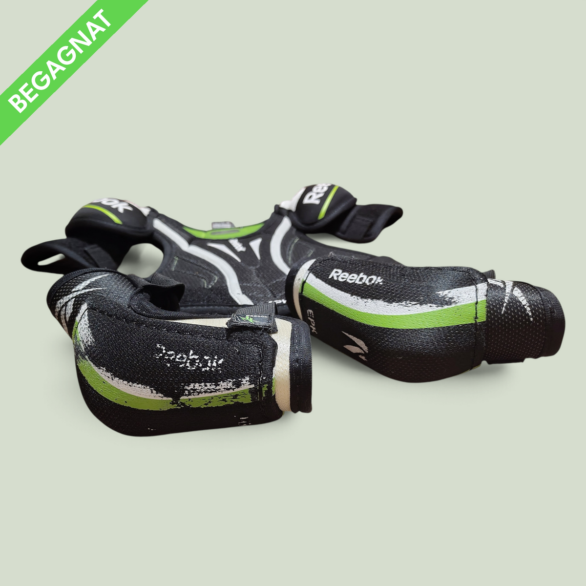 Rörelseboxen youth hockey protective gear set including black and green Reebok shoulder pads and elbow pads